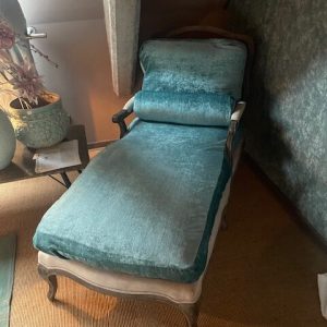 Luksa / Pot en Mand PTMD, Aqua / blauw fluweel met glans. De basis is gemaakt van gebrand vergrijst eiken hout, Het ligbed met basis van beige blauwe linnen stof vulling dons met losse onderzitting deel deze zit vast met klitte band en rug deel en rol kussen, de achter leuning is webbing, Ligbed / chaise longue / ligbank / ligstoel, zithoogte 45 cm hoog met achter kant hoog 97 cm  armleuningen 59 cm hoog, 140 cm lang en 70 cm breed,. ( op voorraad) V1
